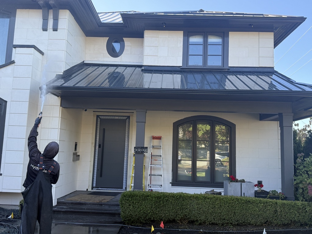 HydroJet crew member washing the exterior wall of a two-storey home